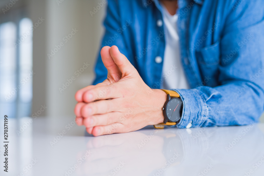 Close up of man hands with palms together over white table Close up of man hands with palms together over white table