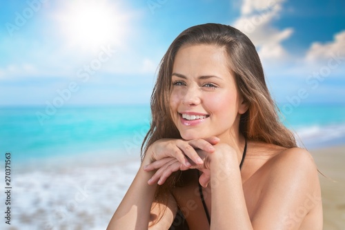 Beautiful Woman with Sunscreen Solar Cream over ocean background. Sun Tanning. Skin care and Protection. Vacation