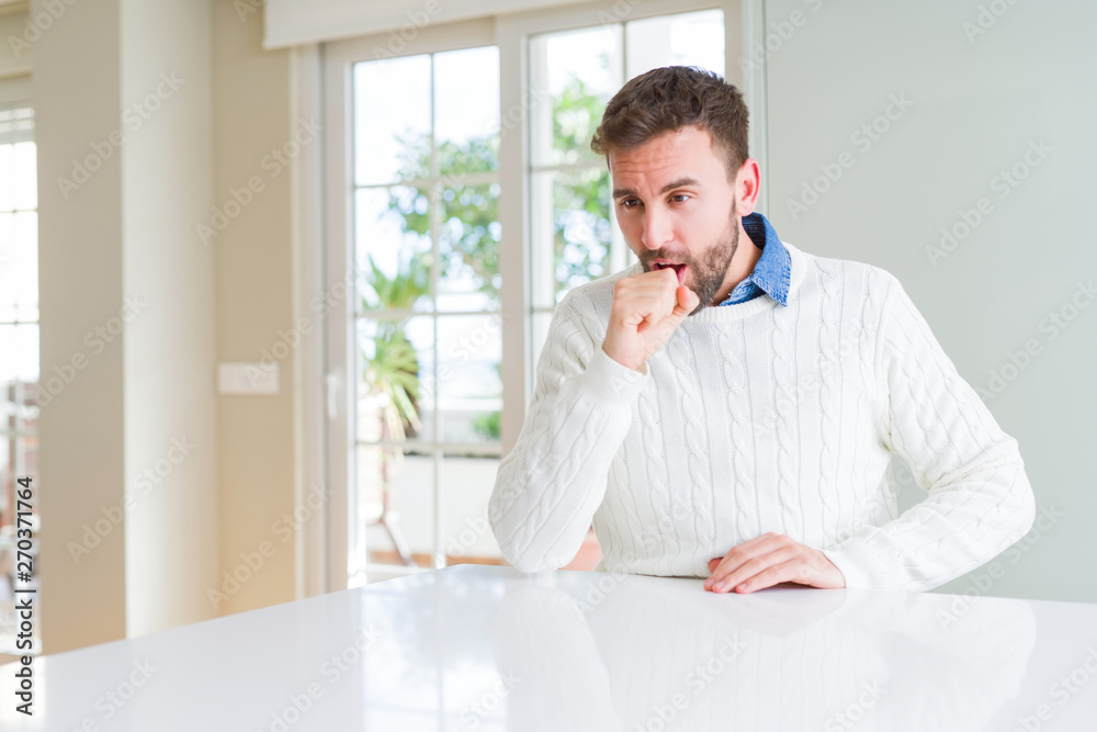 Handsome man wearing casual sweater feeling unwell and coughing as symptom for cold or bronchitis. Healthcare concept.