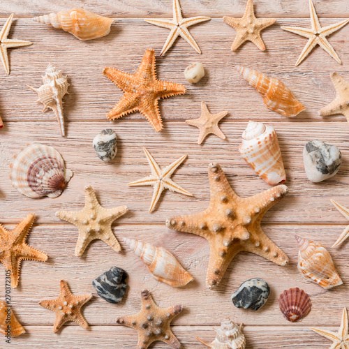 Starfish and seashells background on a wooden table, top view, flat lay