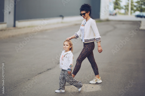 Cheerful mother and daughter having fun in city