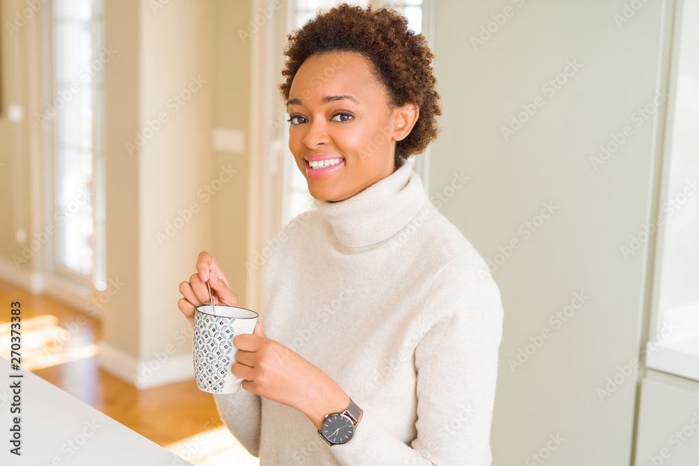 Beautiful young african american woman with afro hair drinking a cup of coffee at home Beautiful young african american woman with afro hair drinking a cup of coffee at home