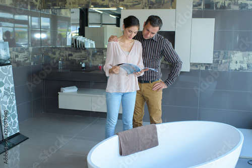 couple looking at oval bath in bathroom store