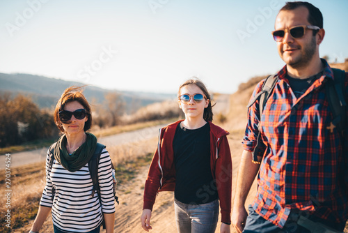 Family hiking together on a mountain dirty road