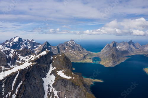 Aerial view of Reine, Lofoten islands, Norway. The fishing village of Reine. Spring time in Nordland. Blue sky. View from above.