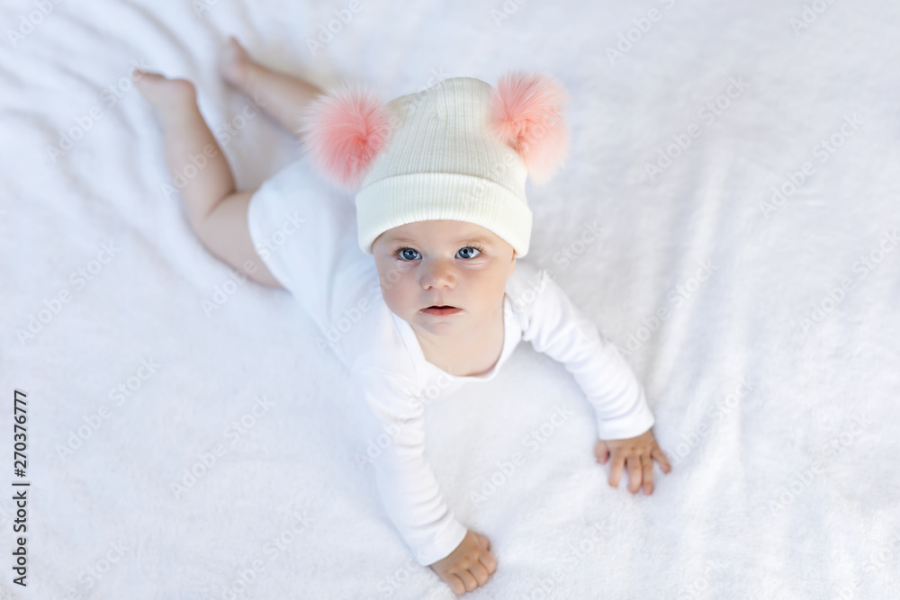 Cute adorable baby child with warm white and pink hat with cute bobbles Cute adorable baby child with warm white and pink hat with cute bobbles