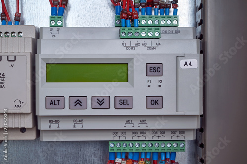 Electric programmable controller for automation of technological processes in the production. Device with LCD display and control buttons. Connect the wires to the device in the electrical Cabinet.