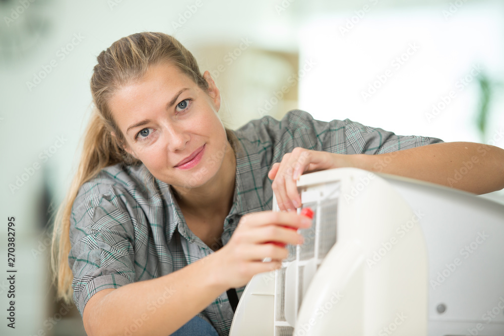 happy young woman checking and cleaning air conditioning happy young woman checking and cleaning air conditioning