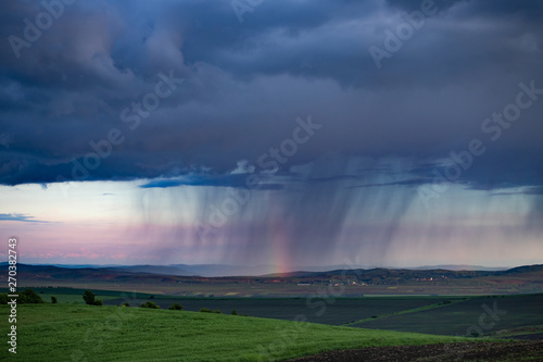 Rainbow and storm over the meadows.