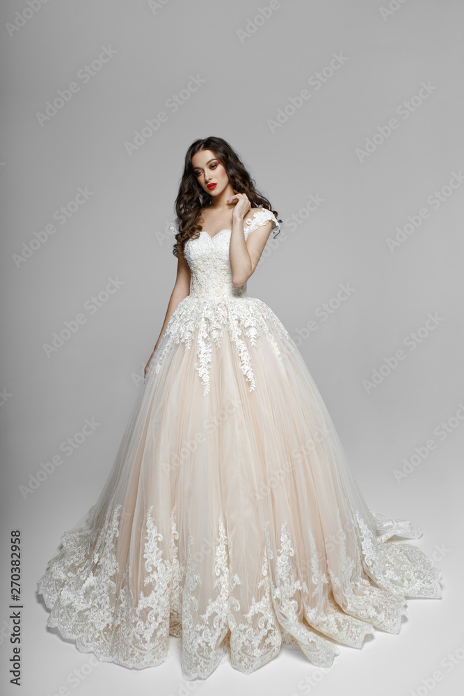 Beautiful girl with curly hair in wendding dress, he touches his neck with his hand, isolated on a white background. Beautiful girl with curly hair in wendding dress, he touches his neck with his hand, isolated on a white background.