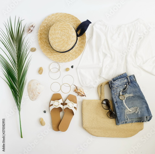 top view, flat lay fashion women summer travel clothes and accessory collage background. Straw hat, shoes, linen trousers, sunglasses , bag and palm leaf. 