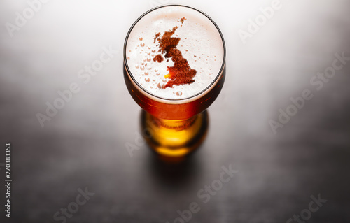 Fototapeta Naklejka Na Ścianę i Meble -  English beer concept, Great Britain silhouette on foam in beer glass on black table. Elements of this image furnished by NASA