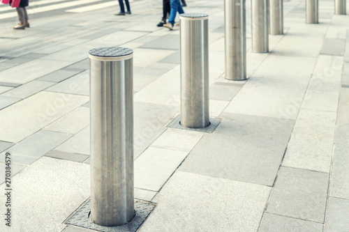 Stainless steel bollard entering pedestrian area on Vienna city street. Car and vehicle traffic access control photo