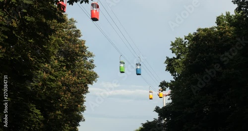 Cableway telpher on a background of blue sky in sunset time different colors diagonal movement photo