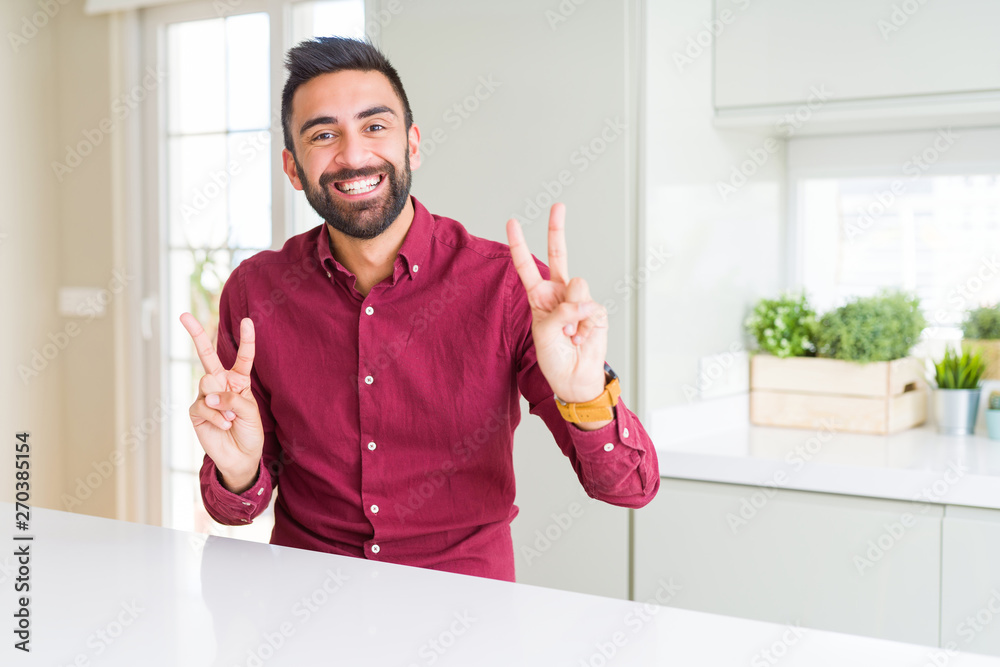 Handsome hispanic business man smiling looking to the camera showing fingers doing victory sign. Number two. Handsome hispanic business man smiling looking to the camera showing fingers doing victory sign. Number two.