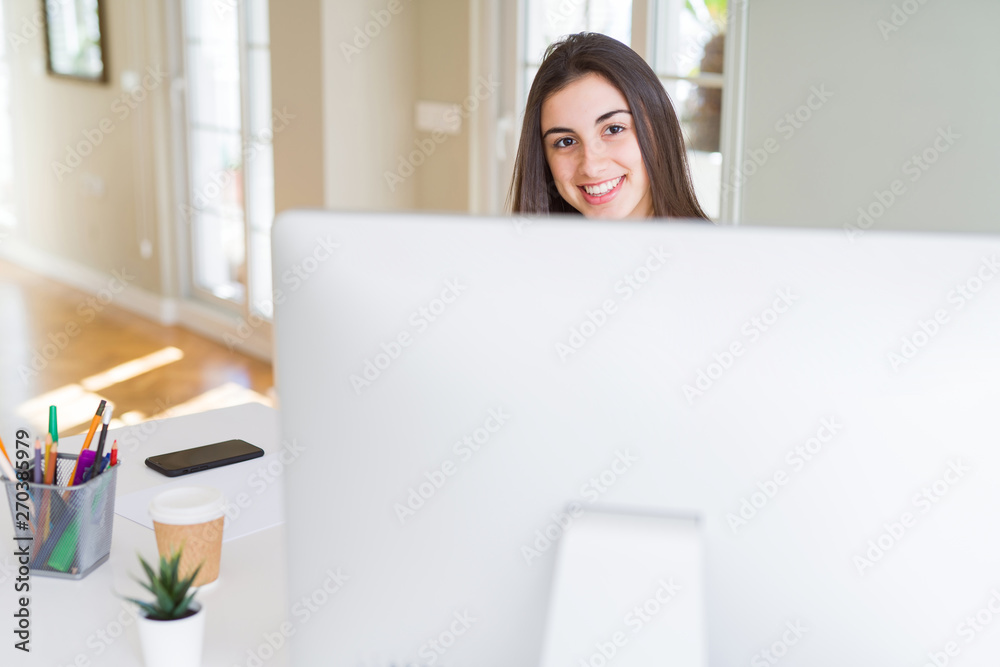 Beautiful young business woman working using computer, smiling and concentrated on online work Beautiful young business woman working using computer, smiling and concentrated on online work