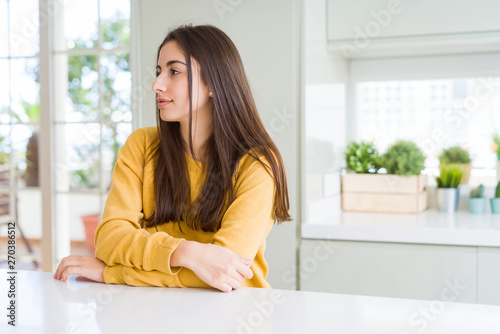 Beautiful young woman wearing yellow sweater looking to side  relax profile pose with natural face with confident smile.