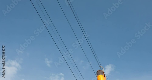 Cableway telpher on a background of blue sky in sunset time different colors diagonal movement photo