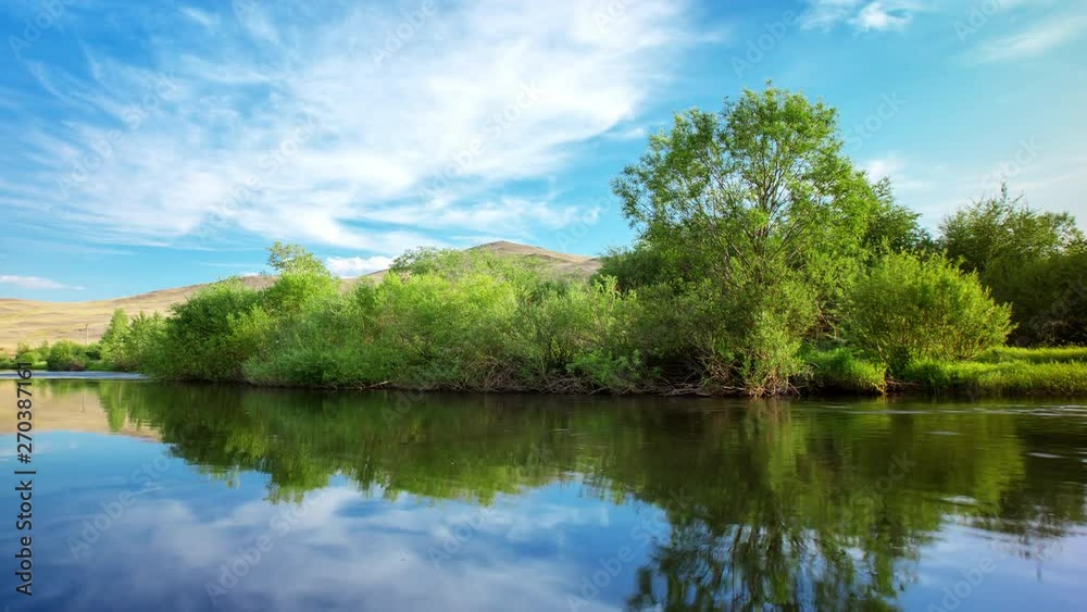 Time-lapse of the moving clouds over a lake surrounded by shrubs Time-lapse of the moving clouds over a lake surrounded by shrubs