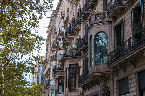 Low-angle view of a row of the urban historic buildings on the Passeig de Gracia stretching into perspective, Barcelona, Catalonia, Spain