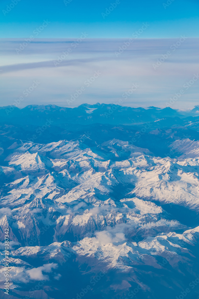 View from the porthole of airplane of a beautiful mountain landscape