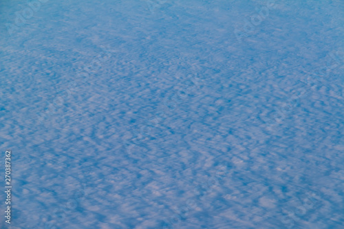 View from the porthole of airplane of a beautiful cloudscape