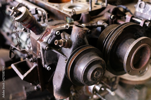 Mechanic repairs old motor of truck in a car repair station. Disassemble engine block vehicle. Motor capital repair. Car service concept