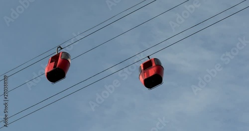 Cableway telpher on a background of blue sky in sunset time different colors diagonal movement photo