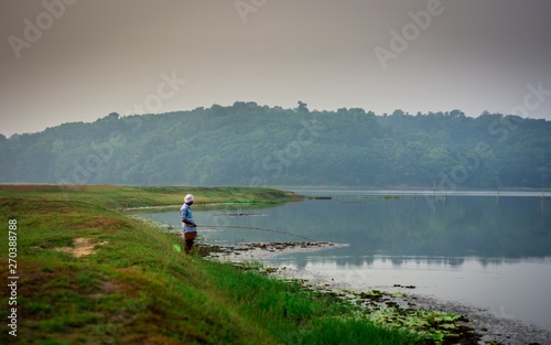 Man fishing with fishing-hook in morning captured from Ithikkunnu, Padapuzha