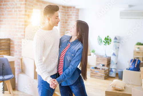 Young asian couple dancing and smiling celebrating moving to a new home