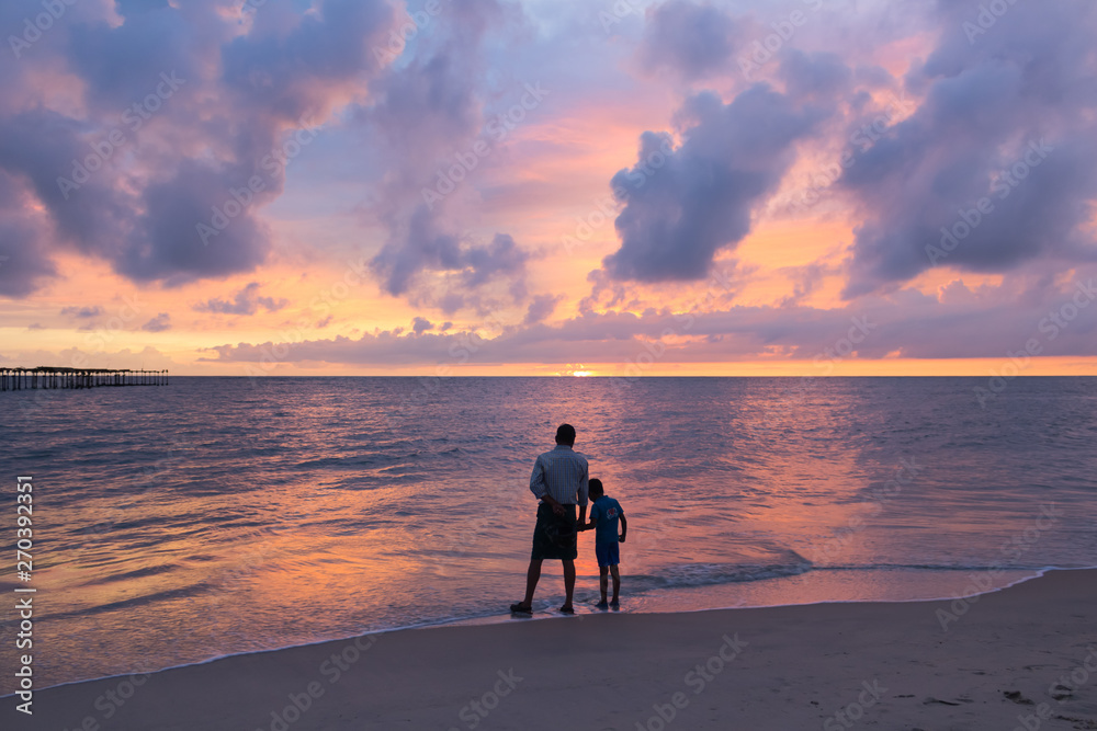Father and son at dramatic sunset in Alleppey Alappuzha Beach Kerala India 