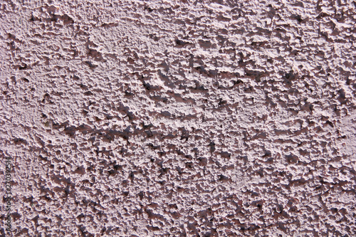 rough pink surface of old a wall with cracks and stains