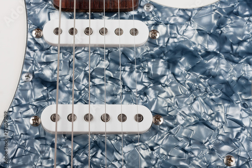 Close up of two single coil on white electric guitar, studio shoot.  Black Pearl pickguard photo