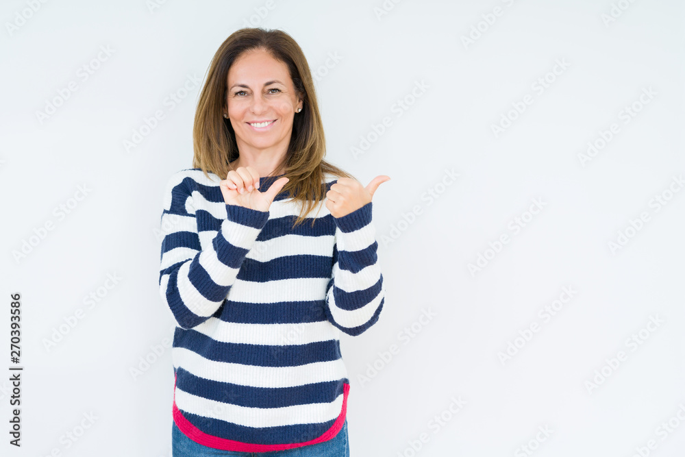 Beautiful middle age woman wearing navy sweater over isolated background Pointing to the back behind with hand and thumbs up, smiling confident Beautiful middle age woman wearing navy sweater over isolated background Pointing to the back behind with hand and thumbs up, smiling confident