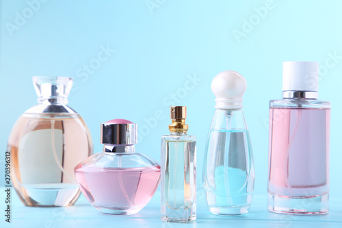 Perfume bottles on blue background, top view