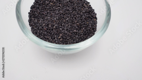 Black sesame seeds in a bowl on white background.It is asian food.