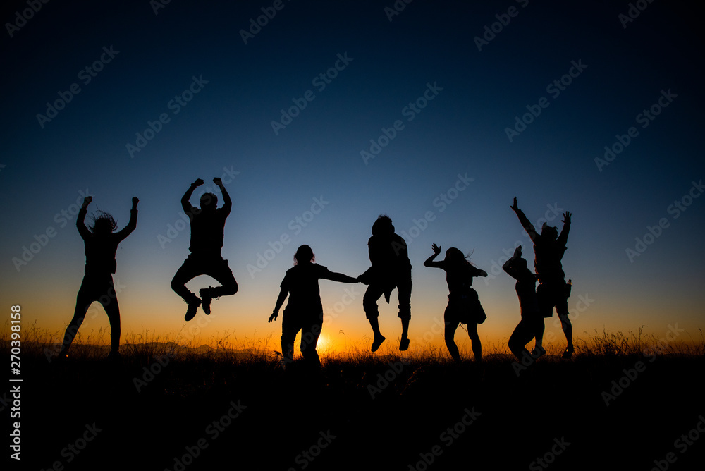 Silhouettes group of people on  mountain with sunset