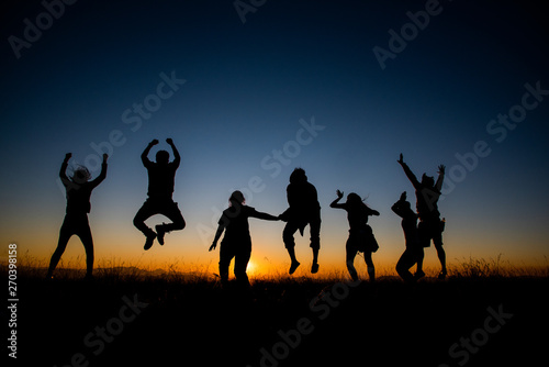 Silhouettes group of people on  mountain with sunset © ic36006