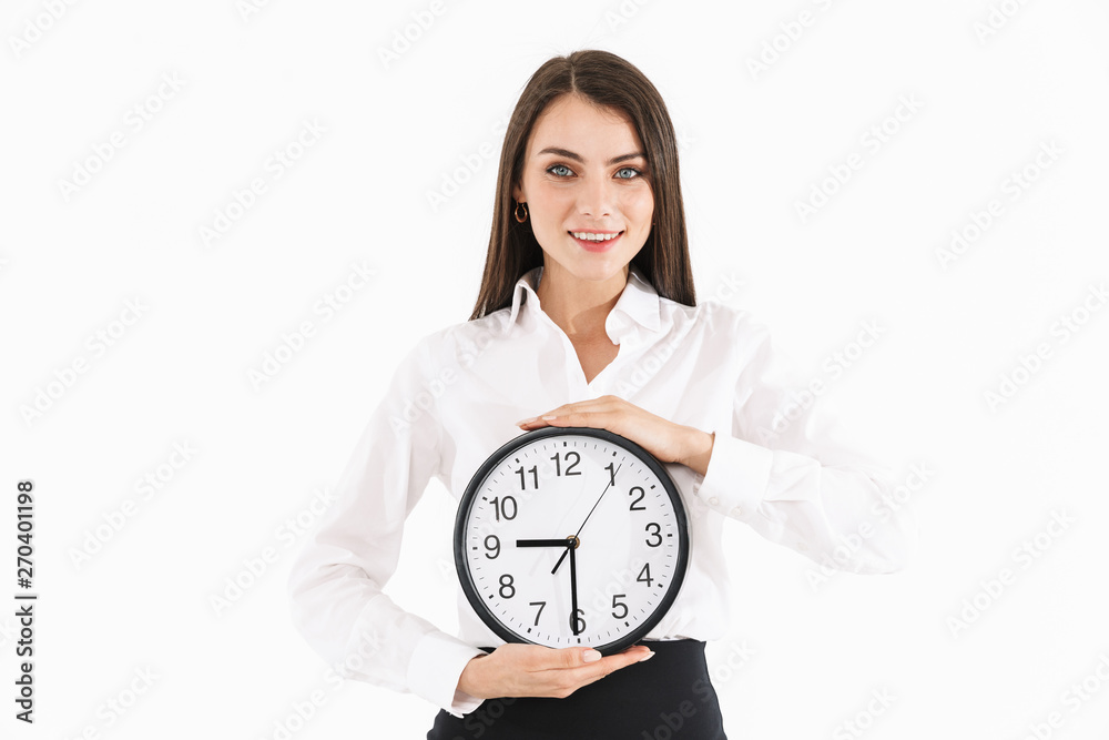 Photo of young female worker businesswoman dressed in formal wear holding big wall clock while working in office Photo of young female worker businesswoman dressed in formal wear holding big wall clock while working in office