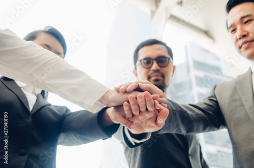 Low Angle View Of Business Team Stacking Hands In Office