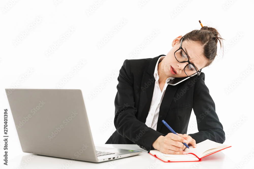 Photo of busy female worker businesswoman dressed in formal wear sitting at desk and working on laptop in office Photo of busy female worker businesswoman dressed in formal wear sitting at desk and working on laptop in office