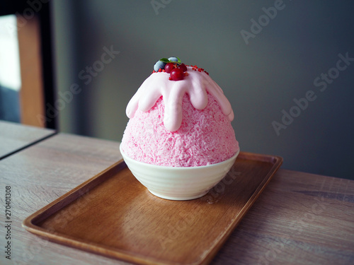 Pink milk kakigori or Japanese shaved ice dessert flavored, Topped with pink whipped cream, blueberry and red currant, same as Bingsu Korean dessert. photo