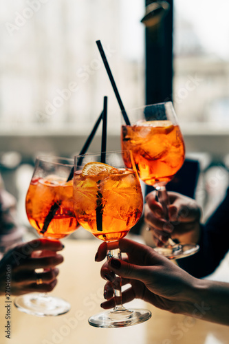 Group of friends cheers with aperol spritz photo