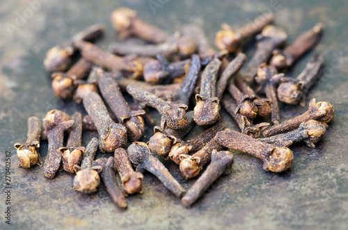 Organic spices, group of cloves, close-up on metal background