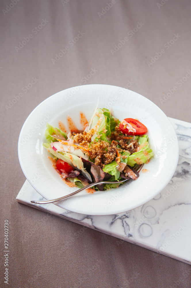 Fresh green mix salad with crispy crumb in white bowl