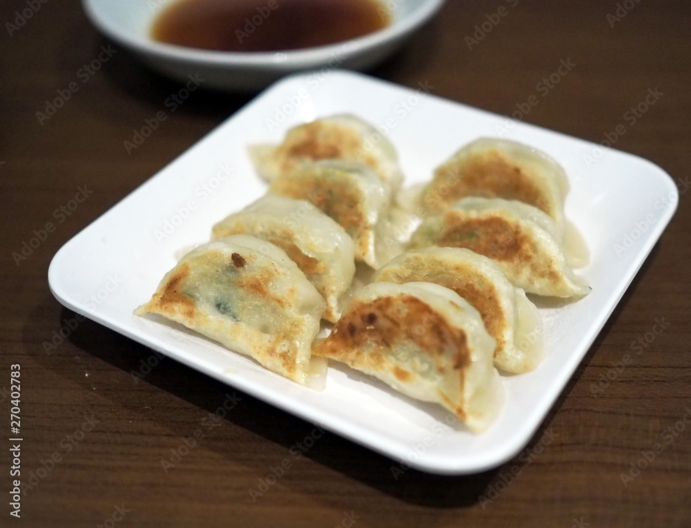 Deep fried gyoza plate served with dipping sauce. Selective focus.