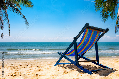 Two beach chairs on white sand, blue sky and summer sea background. Summer concept, holiday, travel, text input area 