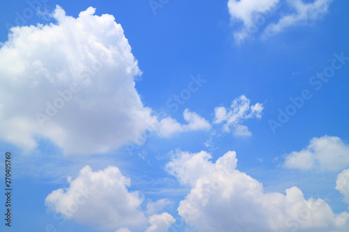 Vibrant sunny blue sky with white fluffy clouds 