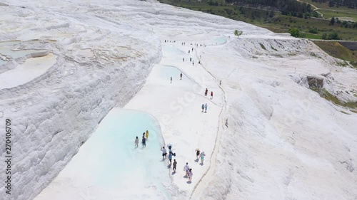 Aerial footage of Pamukkale, Turkey. Tourists walk near artificial travertines. Overall plan 4k