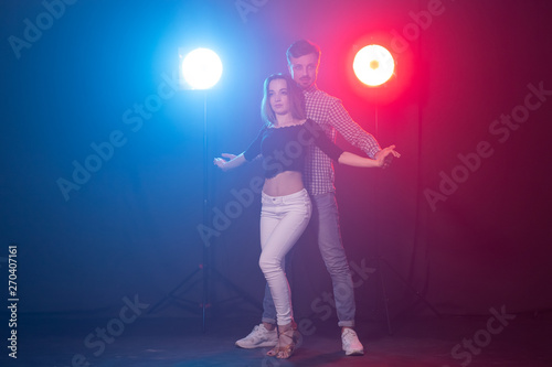 Social dance, kizomba and semba concept - young beautiful couple dancing bachata or salsa in the dark